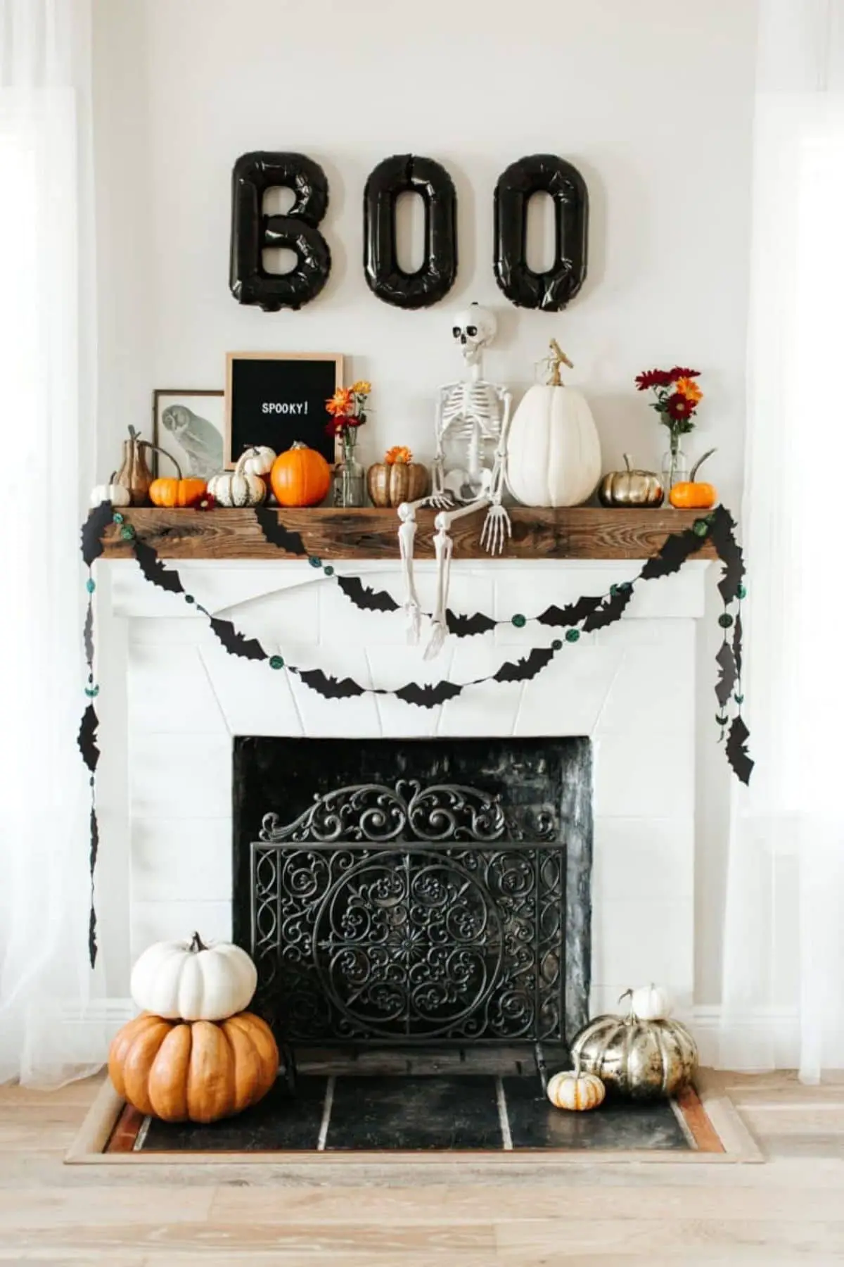mantel decorated with a skeleton and balloons that spell BOO