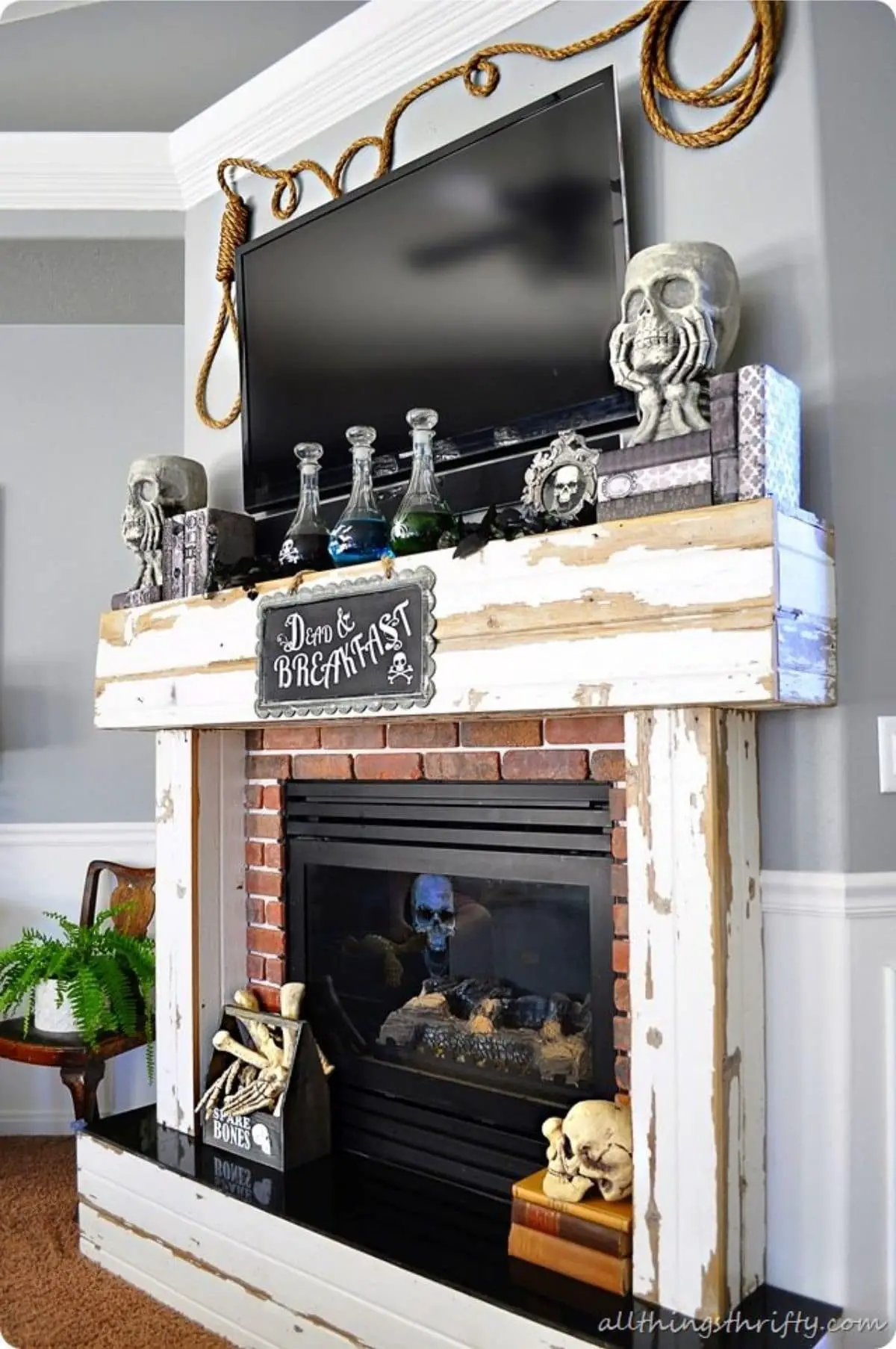halloween mantel decorated with skulls, potions, and picture that says Dead & Breakfast