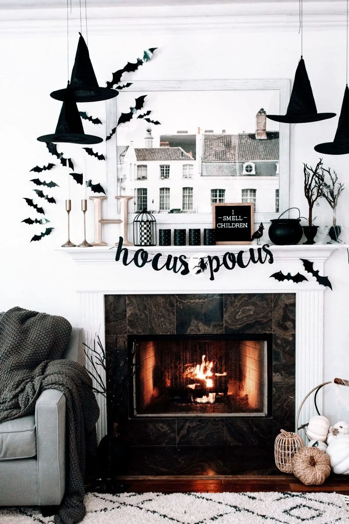mantel with a banner that spells Hocus Pocus, hanging hats, and bats