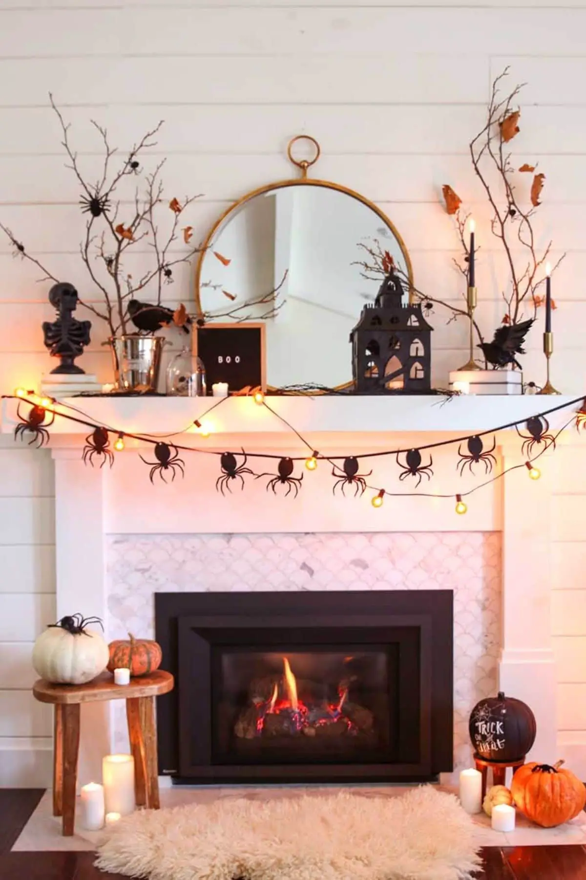 halloween mantel with spiders, pumpkins, and branches