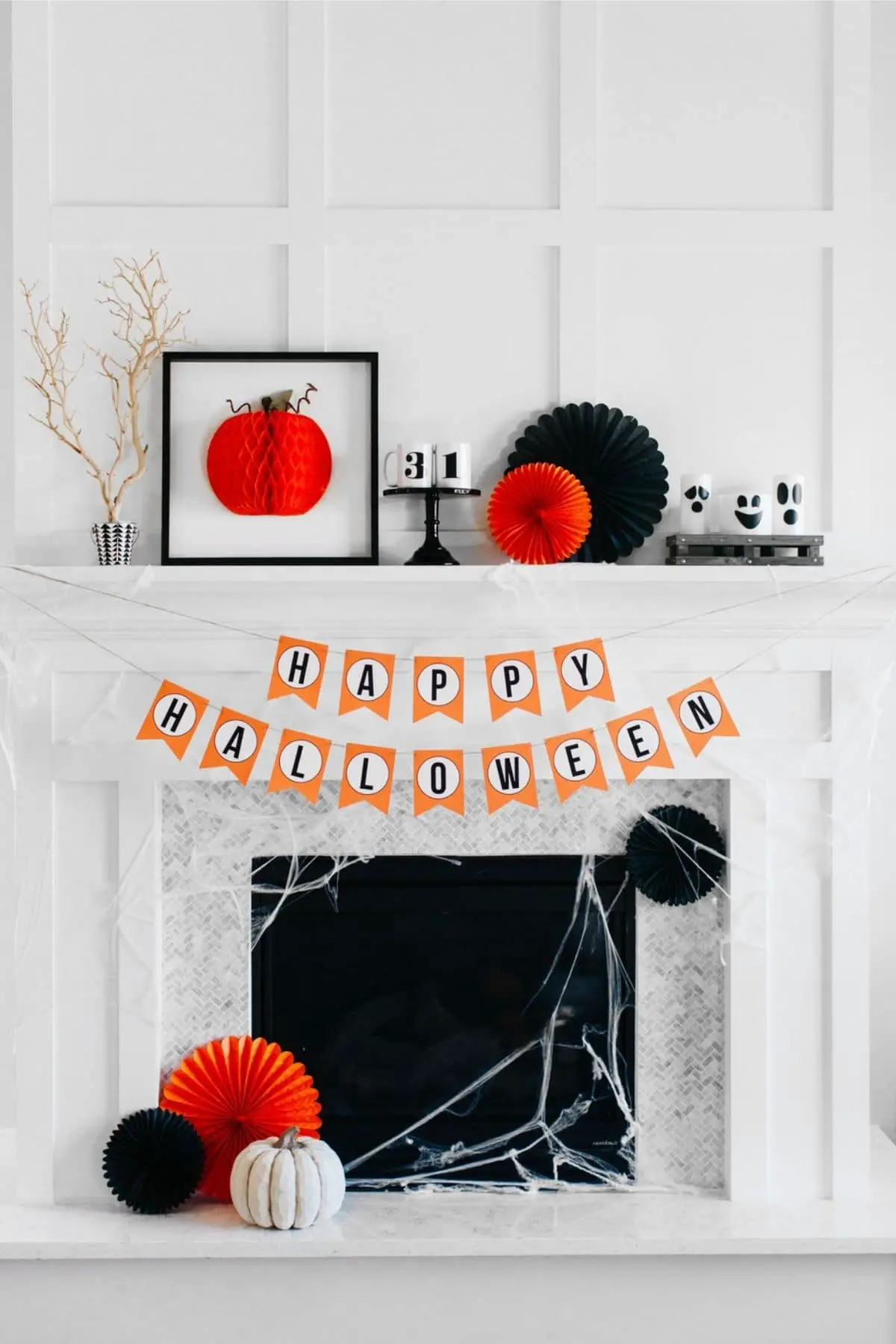 mantel with a happy halloween banner and ghosts