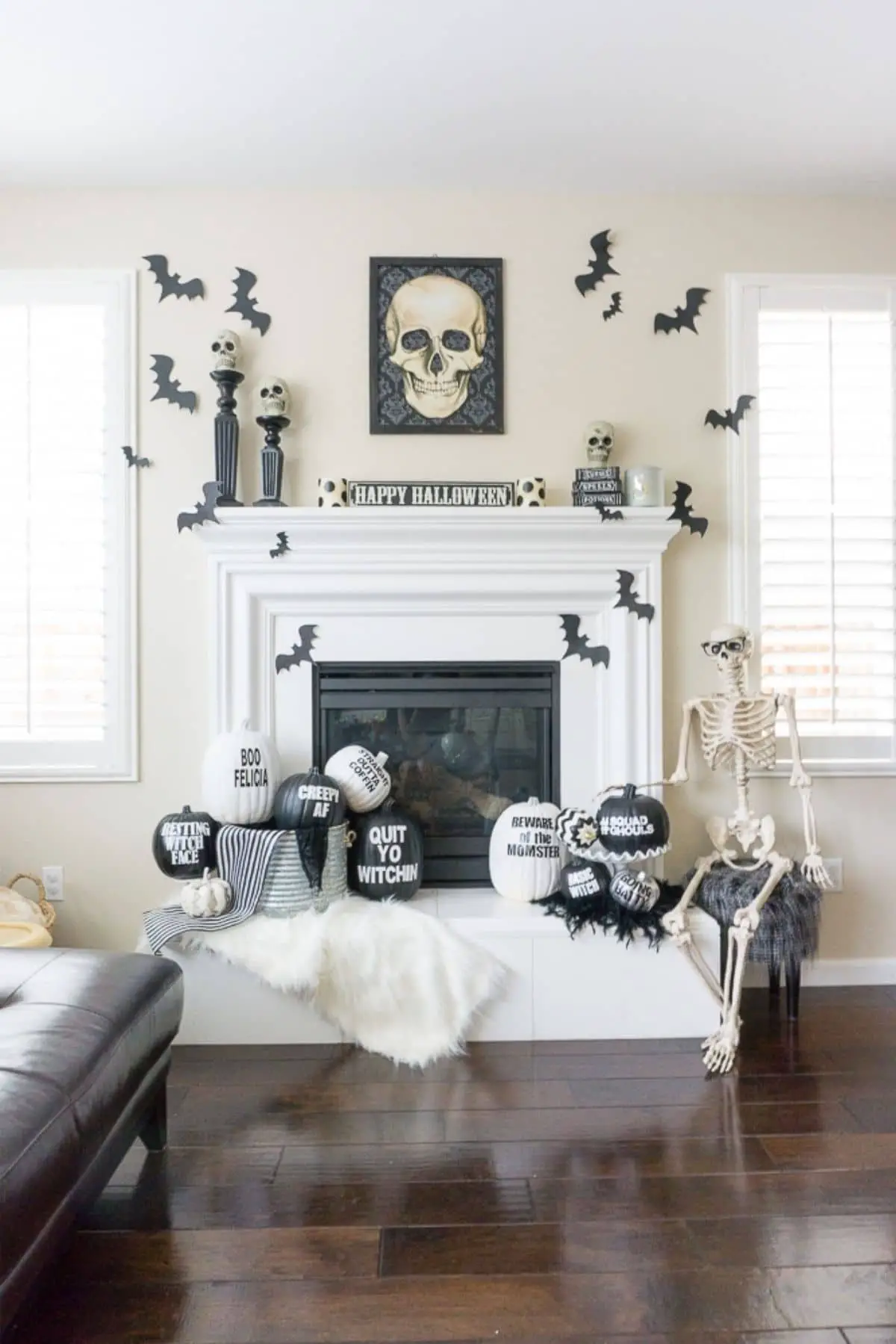 mantel with skulls, bats, pumpkins with sayings on them, and a big skeleton