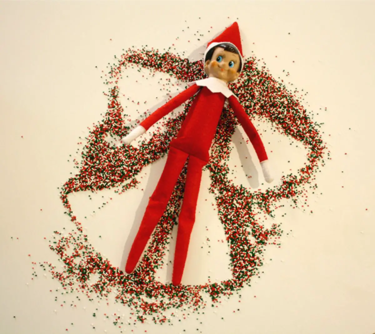 elf on the shelf making snow angel out of sprinkles