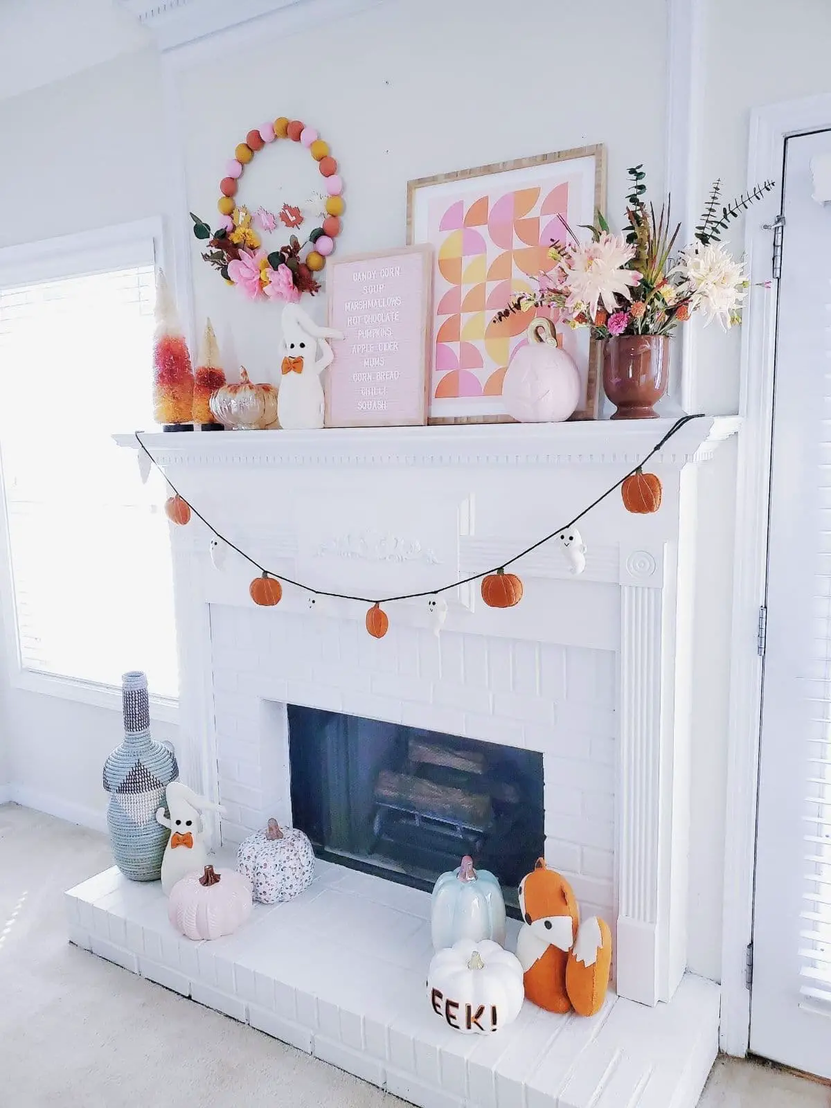halloween mantel with pink pumpkins and ghost banner