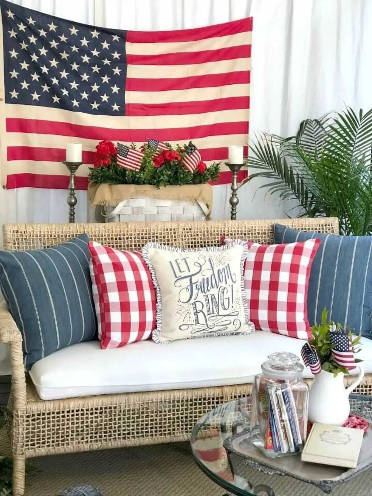 porch with wicker bench with 4th of july pillows and american flag in the background